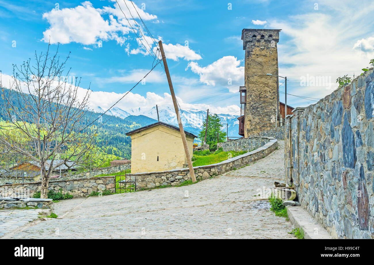 La vieille rue en pierre avec une petite chapelle sur l'ancien cimetière et Svan tower sur arrière-plan, Mestia, Upper Svaneti, Georgia. Banque D'Images