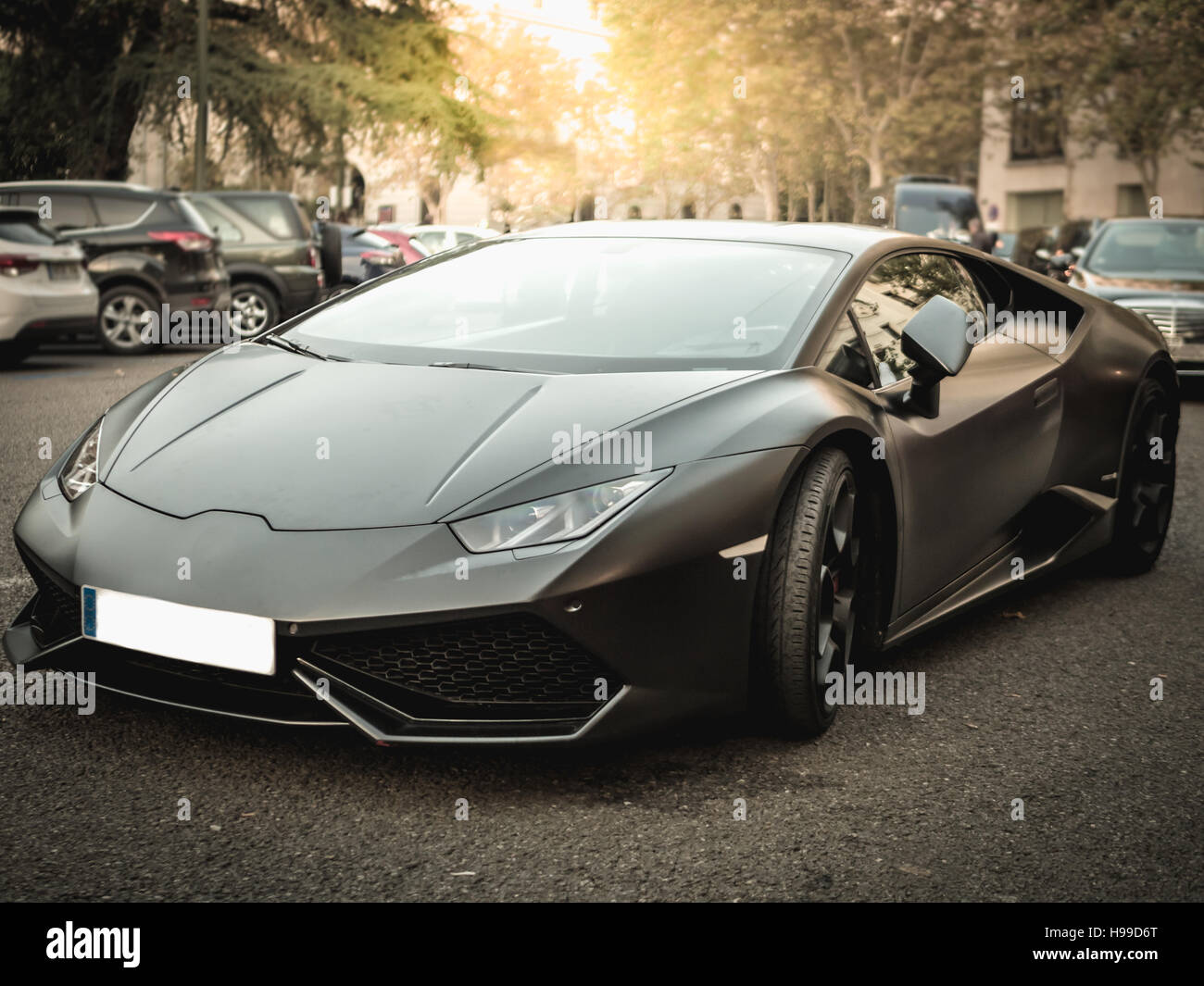Sport de luxe voiture noire dans la rue dans le coucher du soleil Banque D'Images