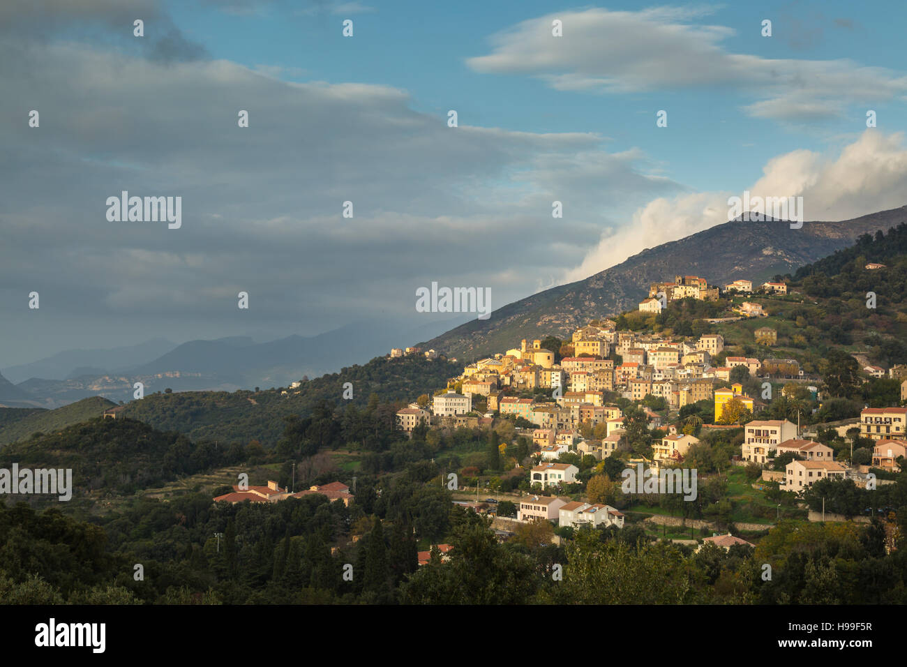 Après-midi, soleil qui brille sur les maisons colorées du village d'Oletta sur une colline dans la région du nord de la Corse Nebbio Banque D'Images