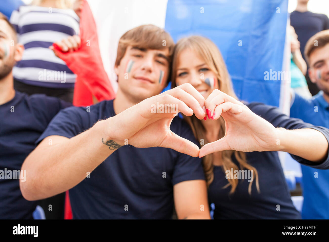Les fans de foot français formant coeur avec les mains Banque D'Images