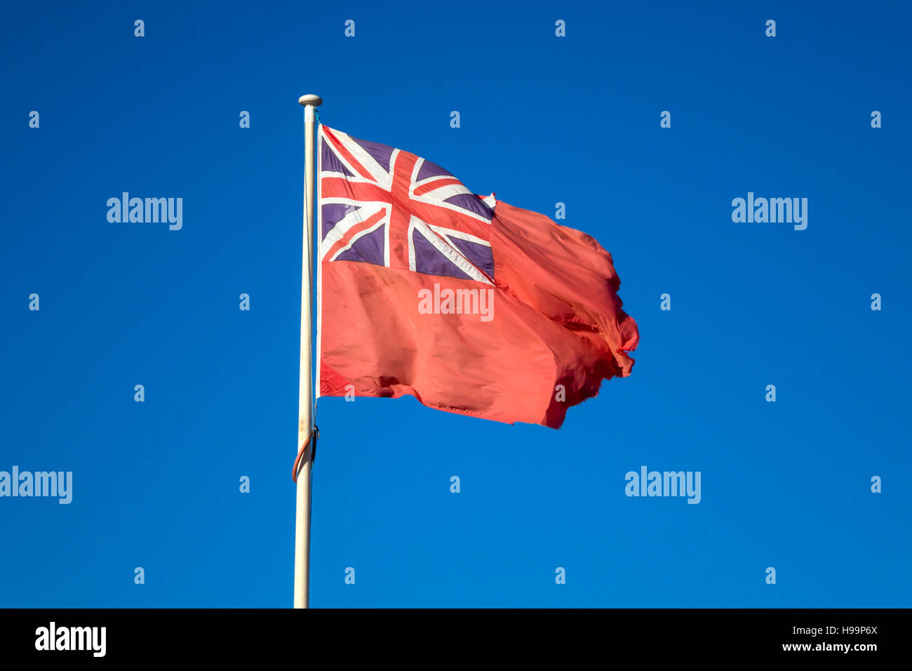 La marine marchande britannique pâle pâle drapeau Le drapeau rouge contre le ciel bleu Banque D'Images