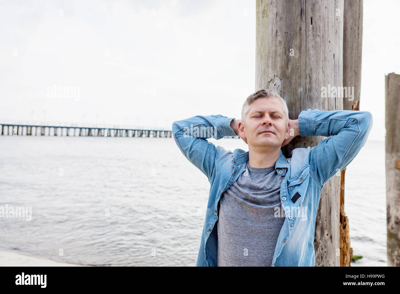 Portrait d'un homme aux cheveux gris se détendre sur la plage Banque D'Images