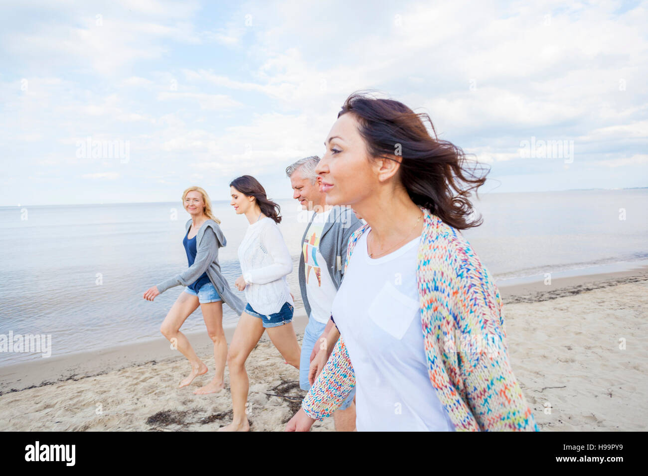 Groupe d'amis, faire une promenade le long de la plage Banque D'Images