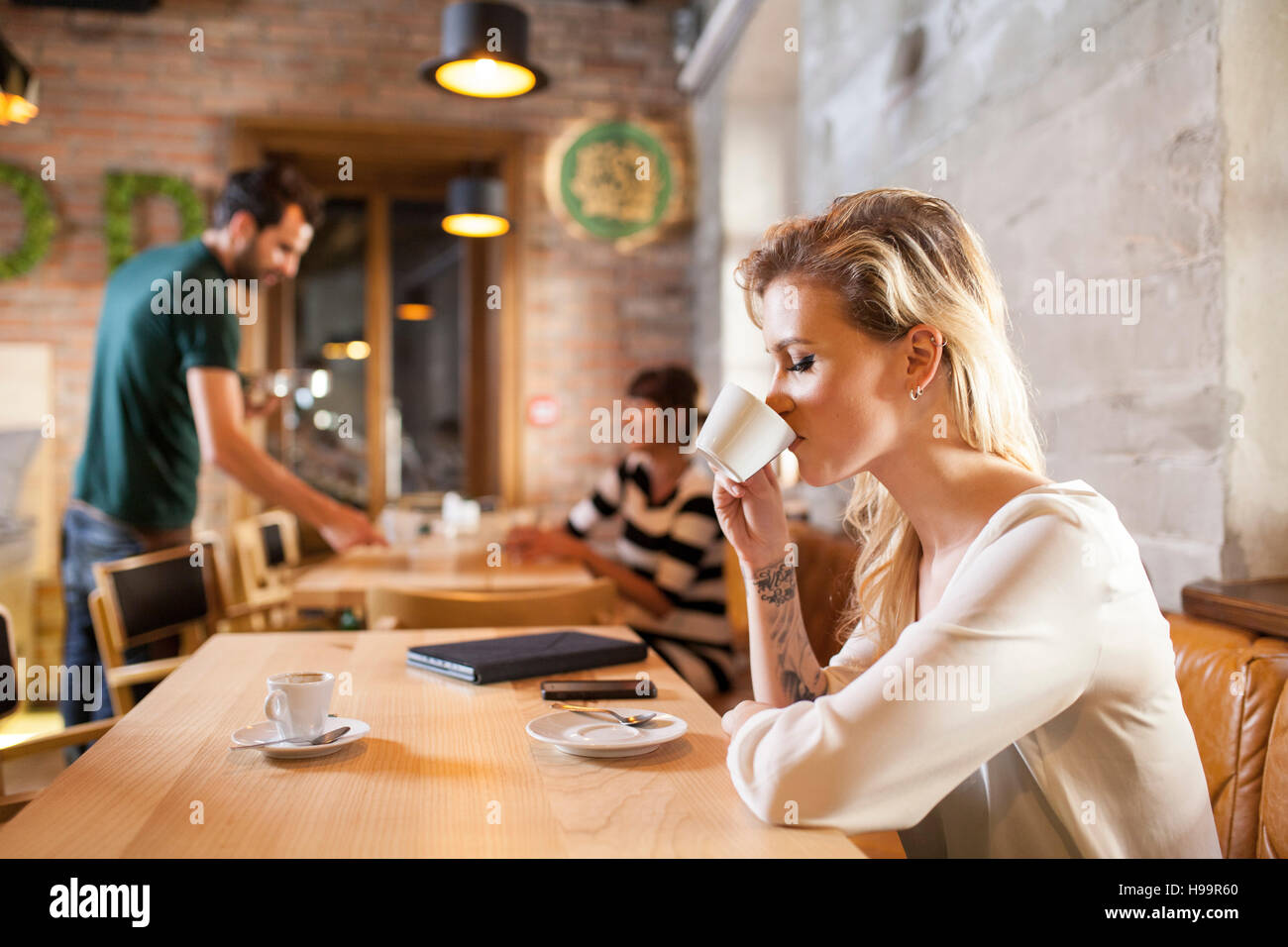 Femme aux cheveux blonds espresso potable in coffee shop Banque D'Images