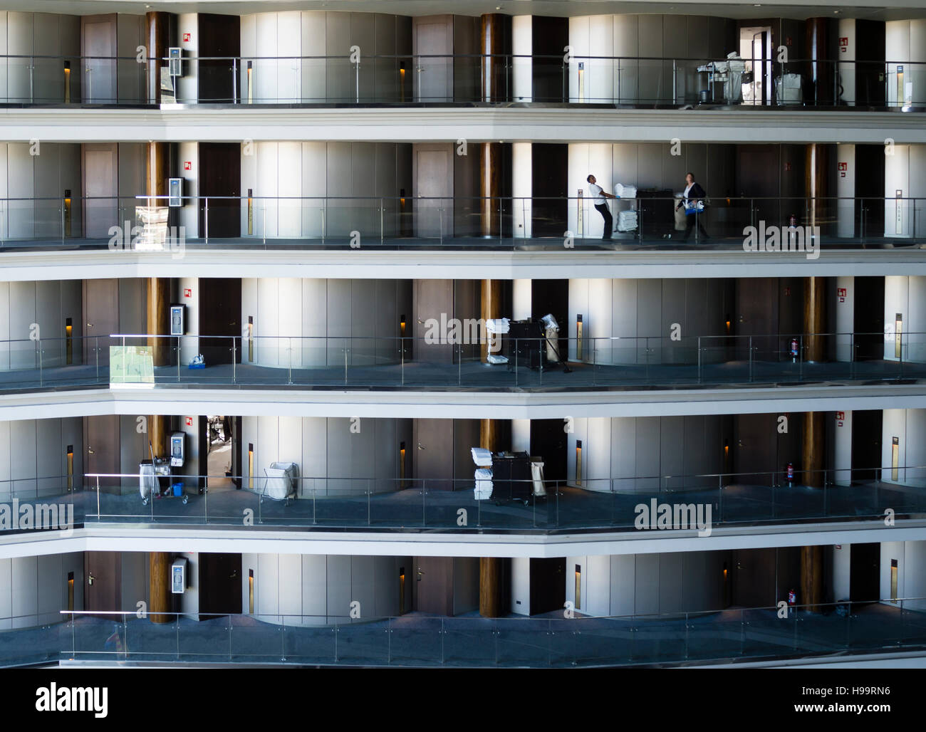 L'équipe de nettoyage d'un grand hôtel d'affaires est de nettoyer le sol de l'hôtel et les chambres. De nombreuses chambres sur plusieurs étages visibles. Banque D'Images