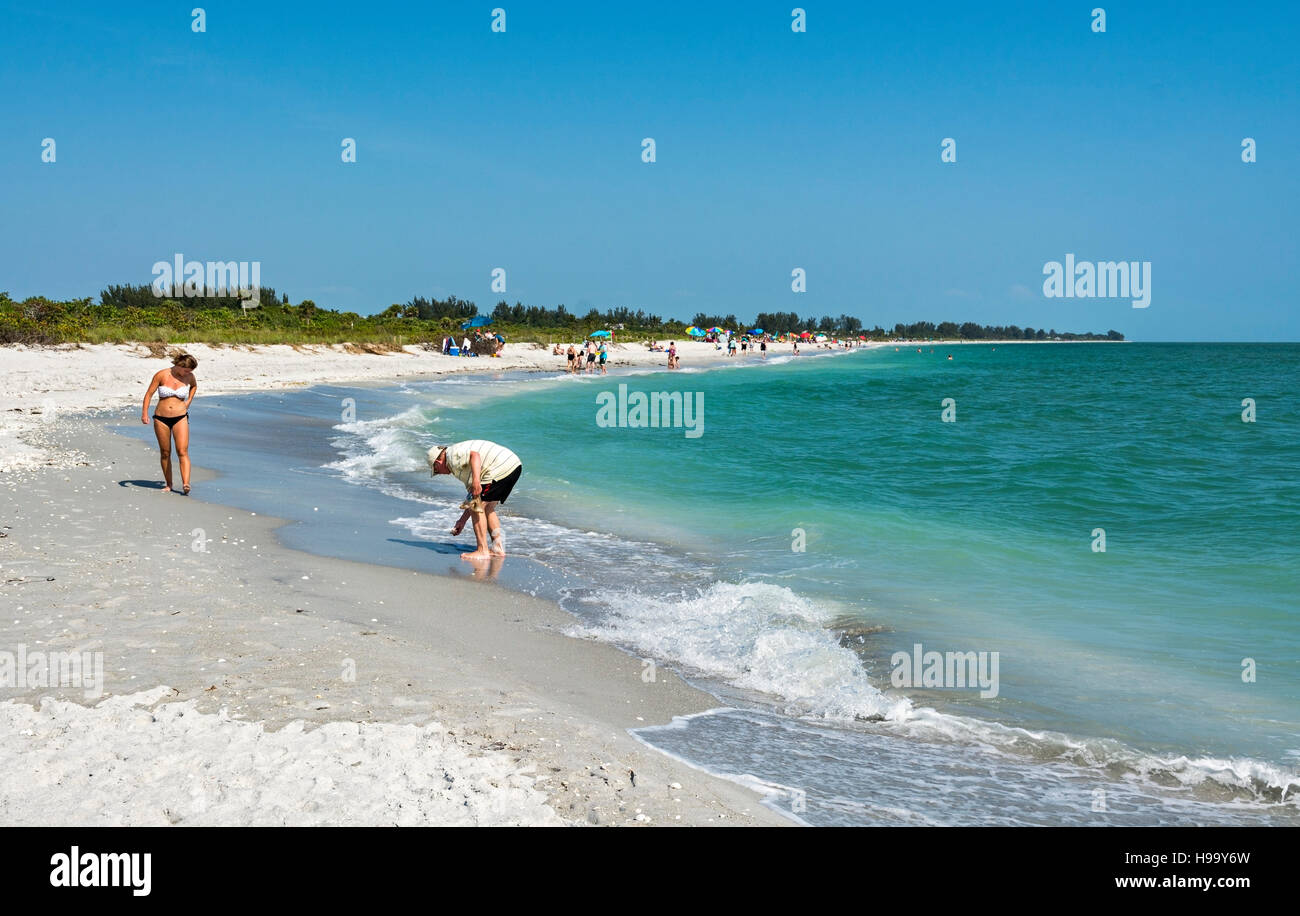 La Floride, l'île de Sanibel, Bowman's Beach, sea shell collector, woman wearing bikini walking along beach Banque D'Images