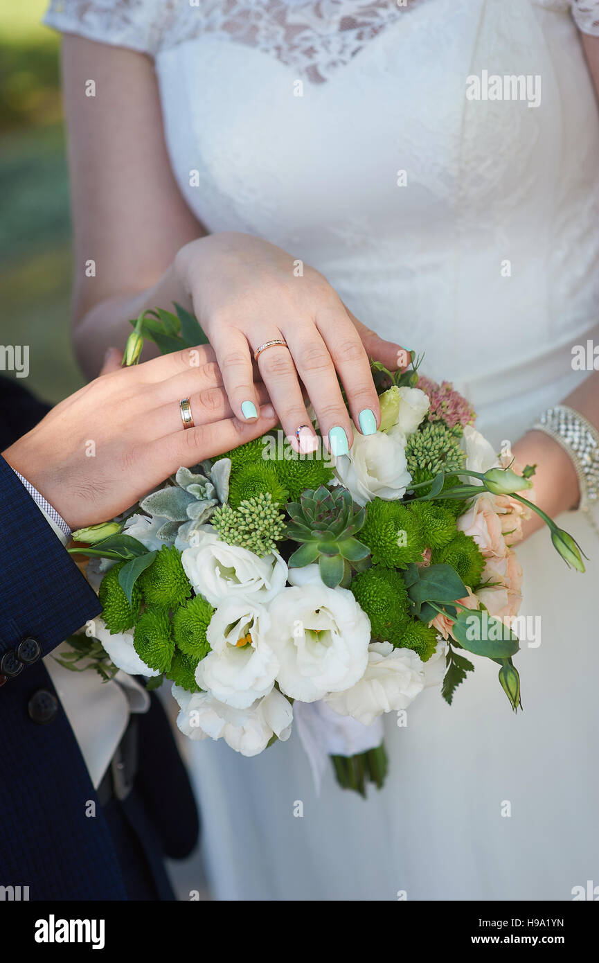 Mains de la mariée et le marié avec joints toriques pour mariage bouquet Banque D'Images