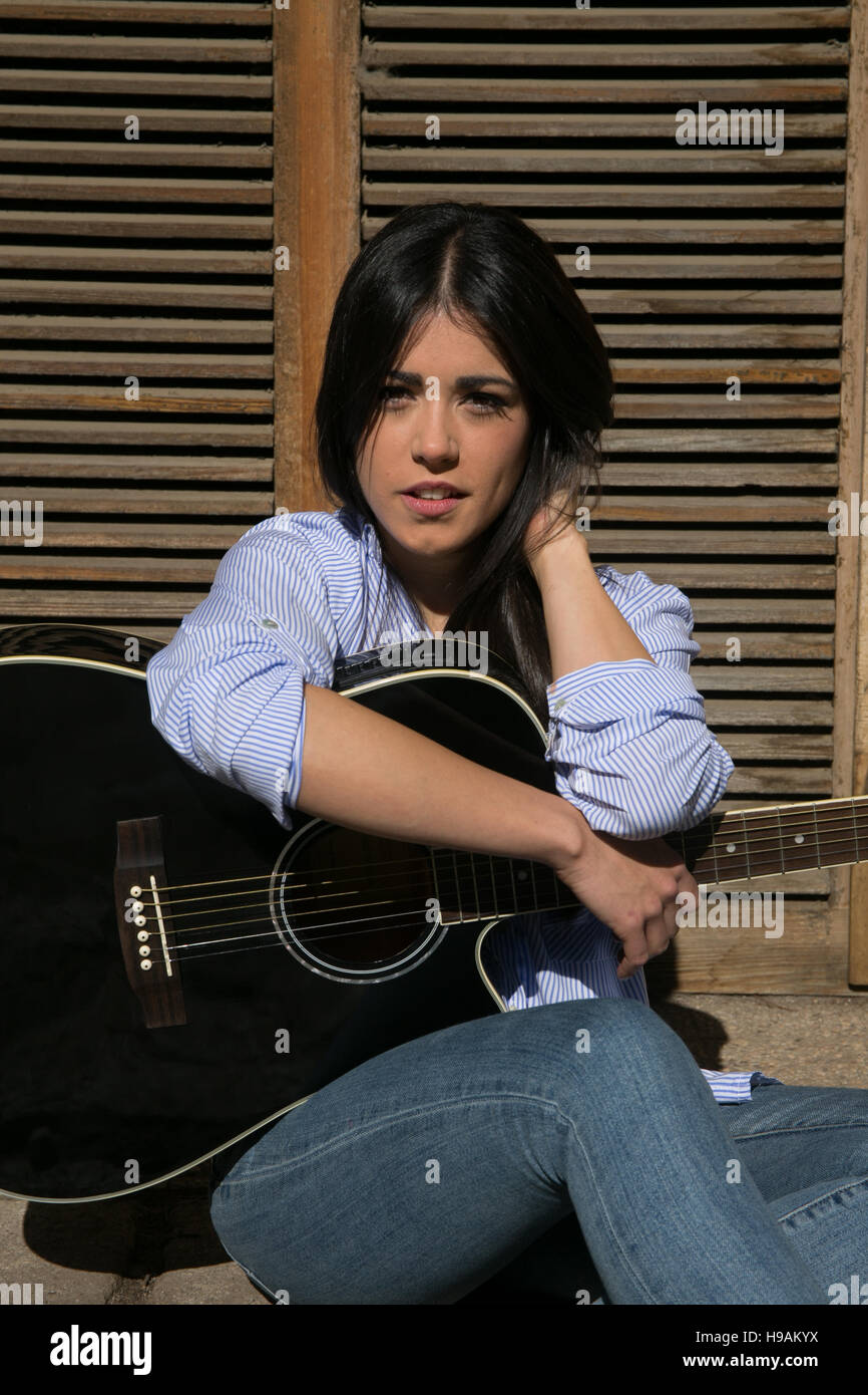 Jeune fille avec un jean et une guitare Banque D'Images