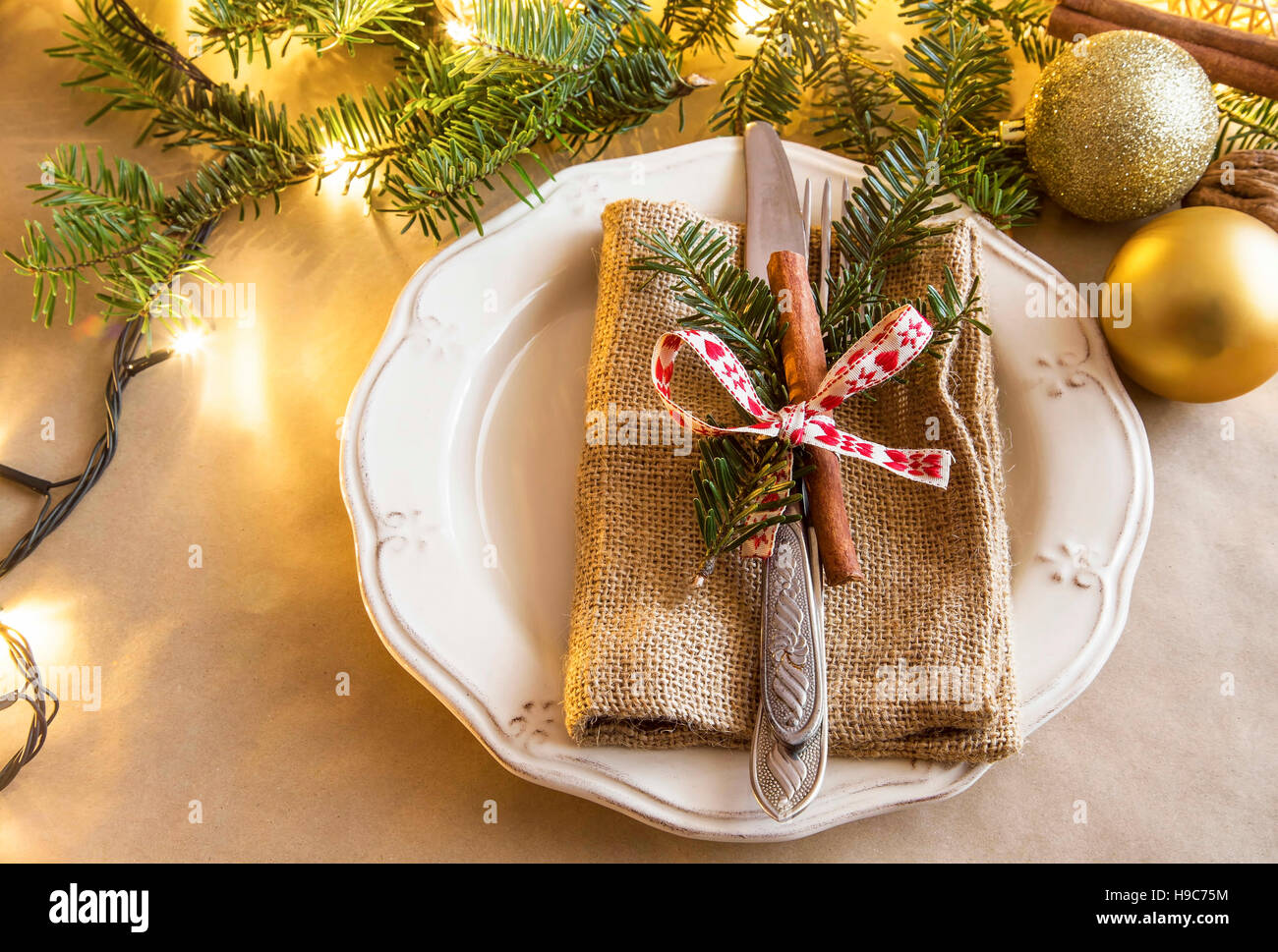 Cadre rustique, Noël, fête table à manger avec une fourchette et couteau décoré de branches de sapins et le bâton de cannelle Banque D'Images
