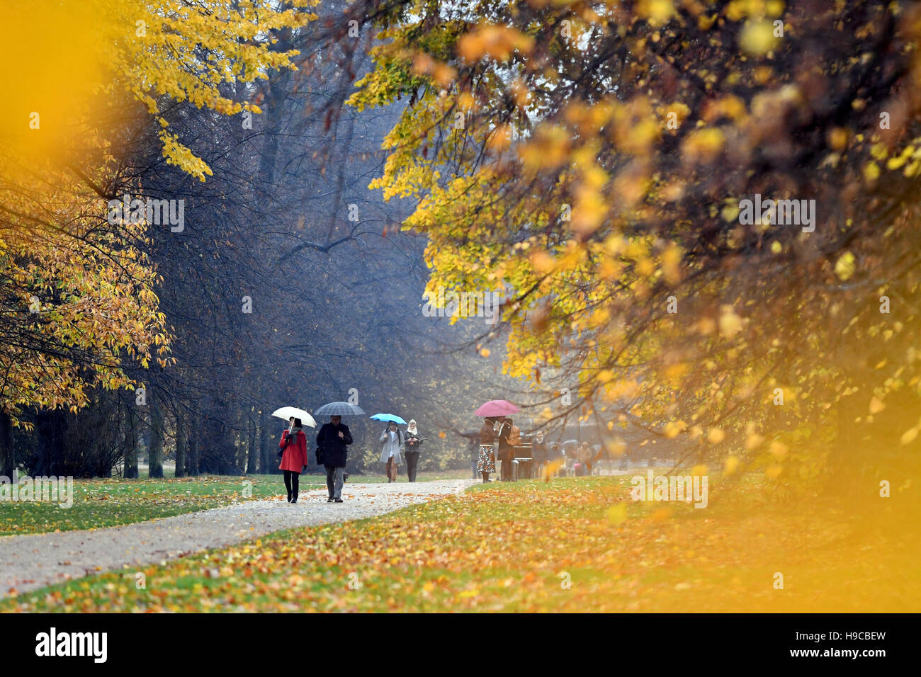 Les marcheurs à Hyde Park, Londres brave la pluie que Storm Angus continue de balayer l'ensemble du Royaume-Uni. Banque D'Images