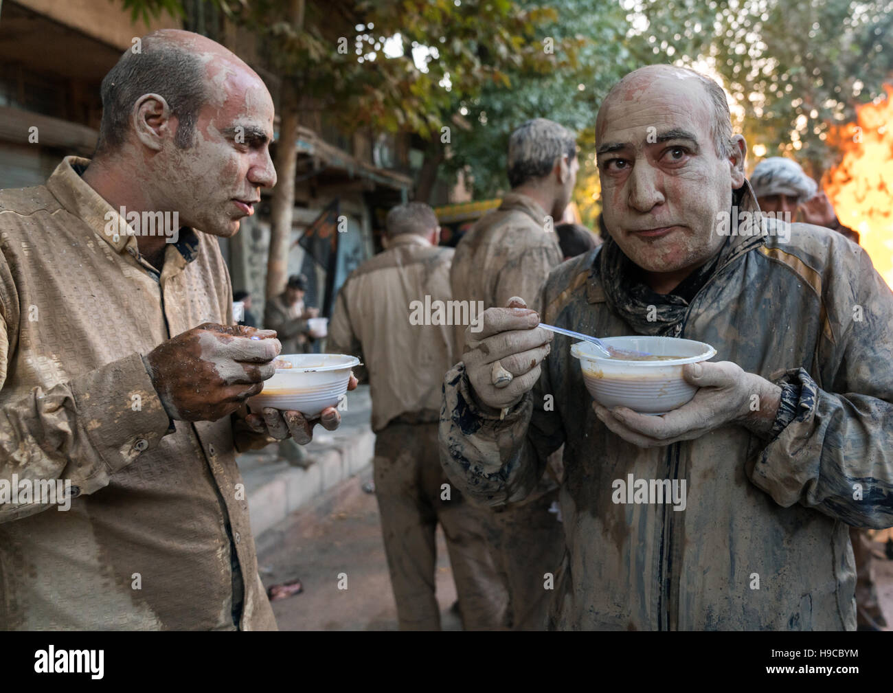 Musulman chiite iranien les hommes mangent leurs petits déjeuners après frottement de la boue sur leurs corps tôt le matin du jour de ashoura, la province du Lorestan, Khorramabad, J Banque D'Images