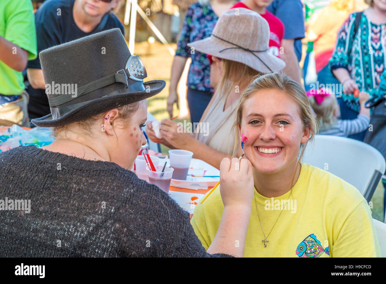 Young woman getting son visage peint à un festival d'automne à Gulfport, Mississippi Banque D'Images