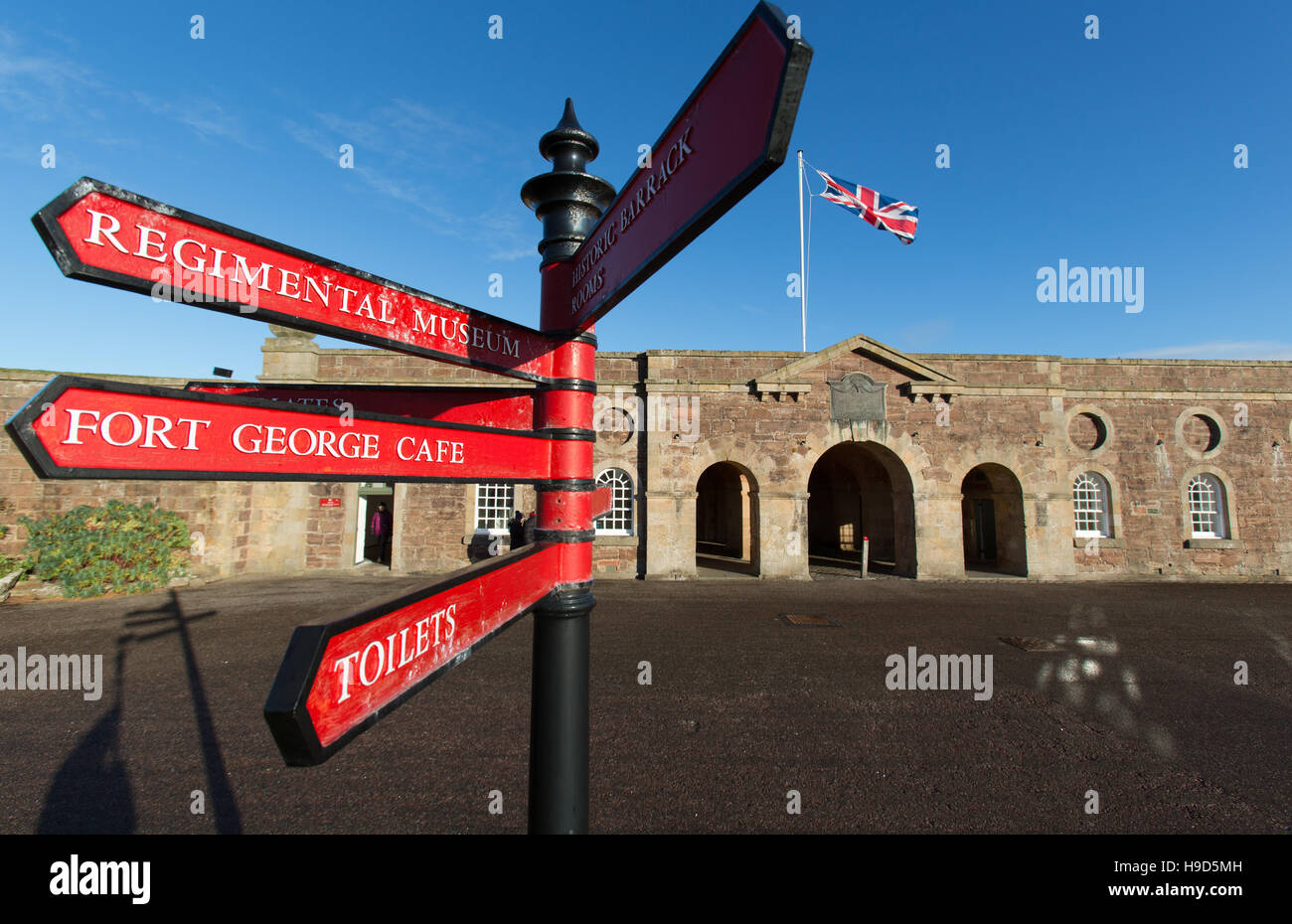 Fort George en Écosse. Panneau direction visiteur, avec l'entrée principale de Fort George et guardrooms dans l'arrière-plan. Banque D'Images