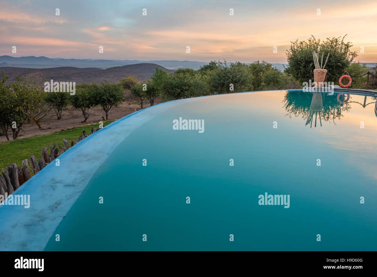 Matin nuages colorés et vert arbres namibien se reflètent dans un miroir d'une piscine de l'hôtel Banque D'Images