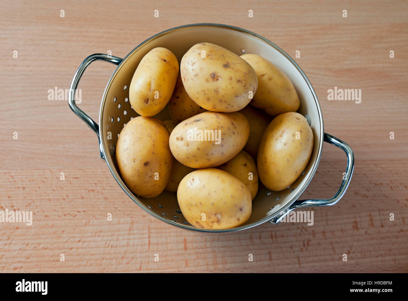 Légumes crus non cuits légumes pommes de terre nouvelles dans un bol à passoire récipient pot par le dessus Banque D'Images