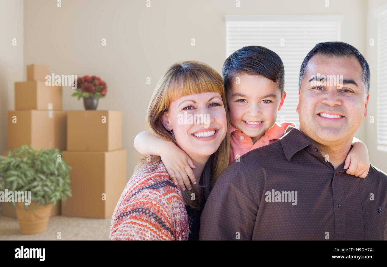 Happy Mixed Race Family avec bébé dans la chambre avec des paniers-Moving Boxes. Banque D'Images