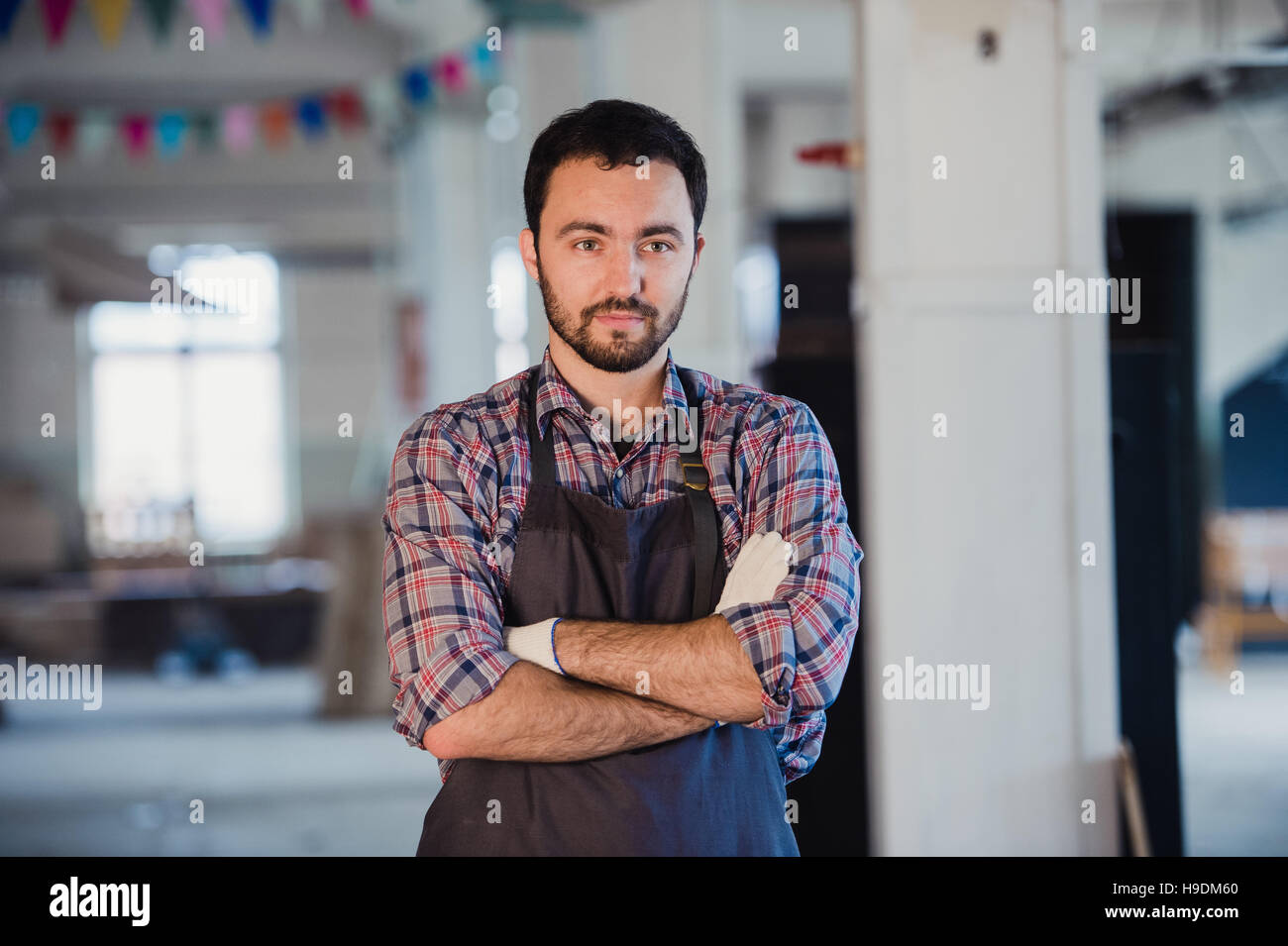Atelier est mon monde. Young male carpenter en gardant les bras croisés Banque D'Images