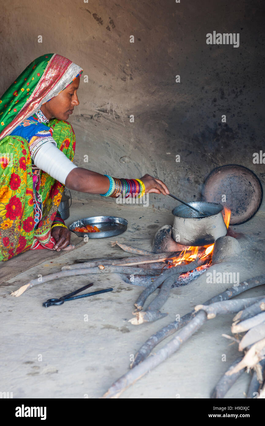 Un meghawal tribal femme prépare le déjeuner, hodka dans une région semi-aride bordant les Grands raan de Kutch. Banque D'Images