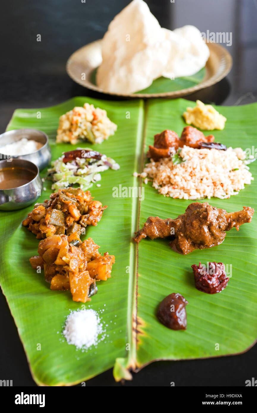 Une feuille de bananier avec viande thali curry, plats de légumes différents, plus une poignée de chutneys, dal, yaourt, riz et papadams Banque D'Images