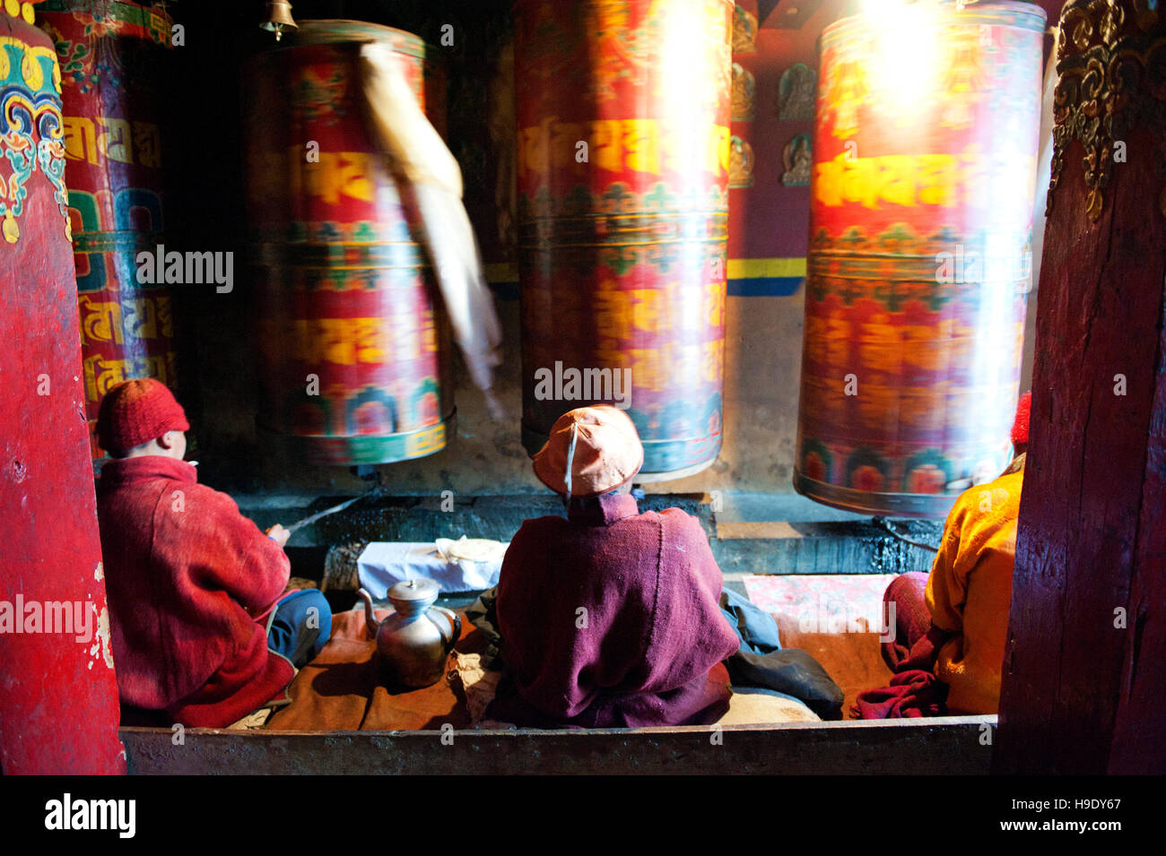 Moines au monastère de Tawang grand spin roues de prière tout en chantant des prières bouddhistes dans la vallée de Tawang à distance, de l'Inde. Banque D'Images