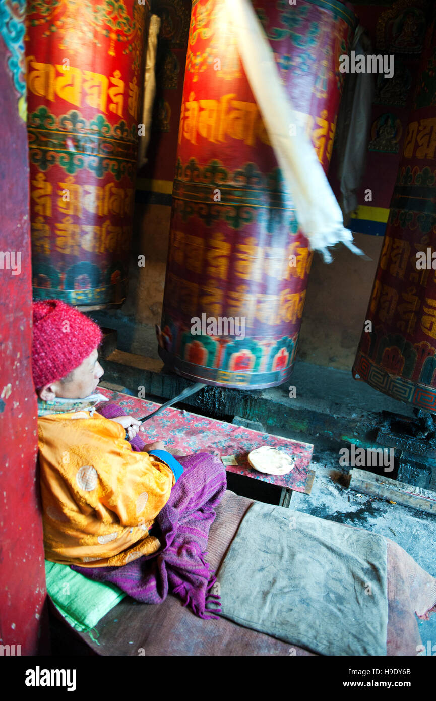 Moines au monastère de Tawang grand spin roues de prière tout en chantant des prières bouddhistes dans la vallée de Tawang à distance, de l'Inde. Banque D'Images