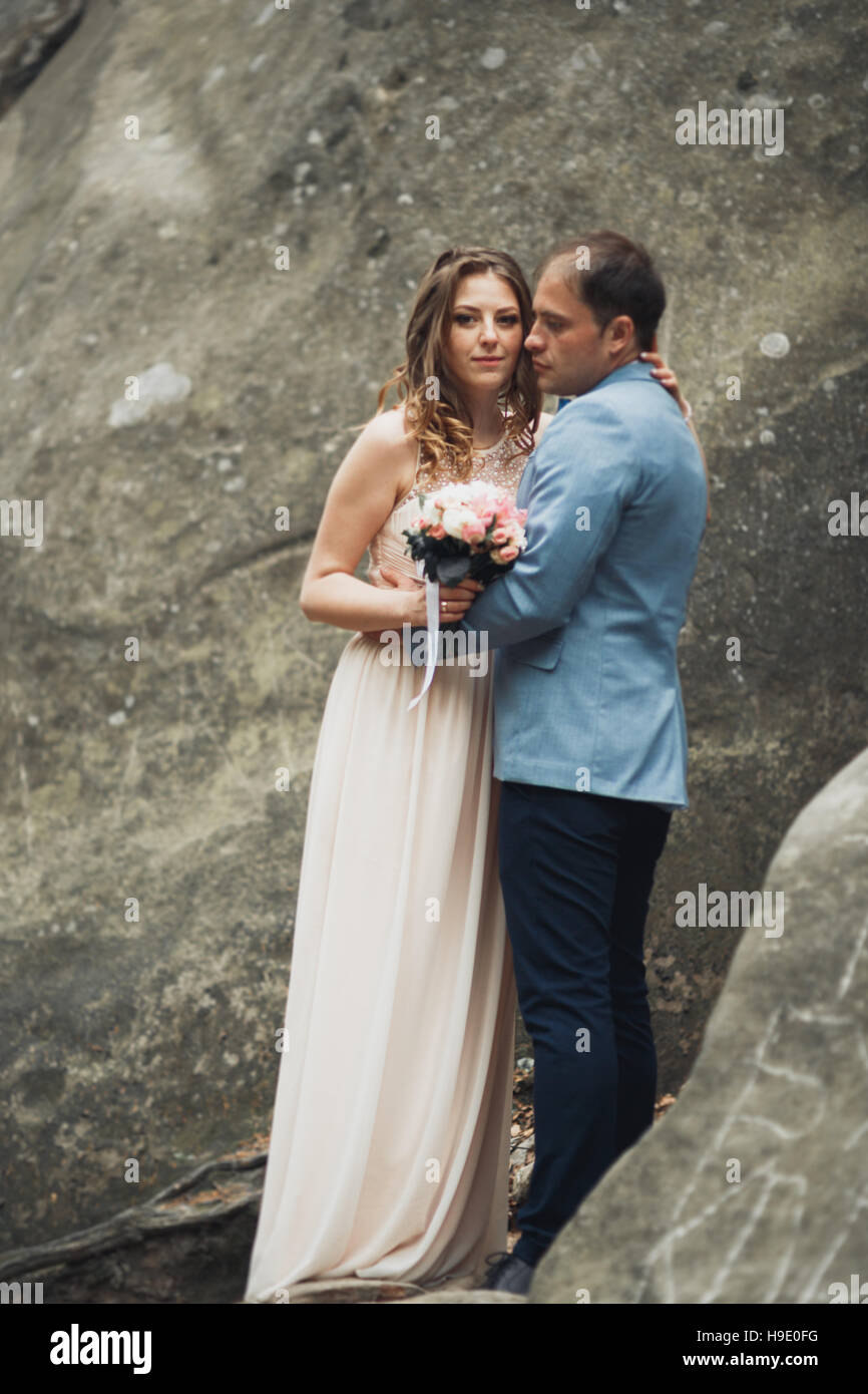 Happy wedding couple embrasser et s'étreindre près d'une haute falaise Banque D'Images