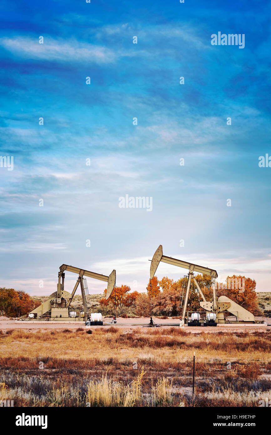 Retro photo aux couleurs de deux pompes à huile, vieux matériel industriel. Banque D'Images