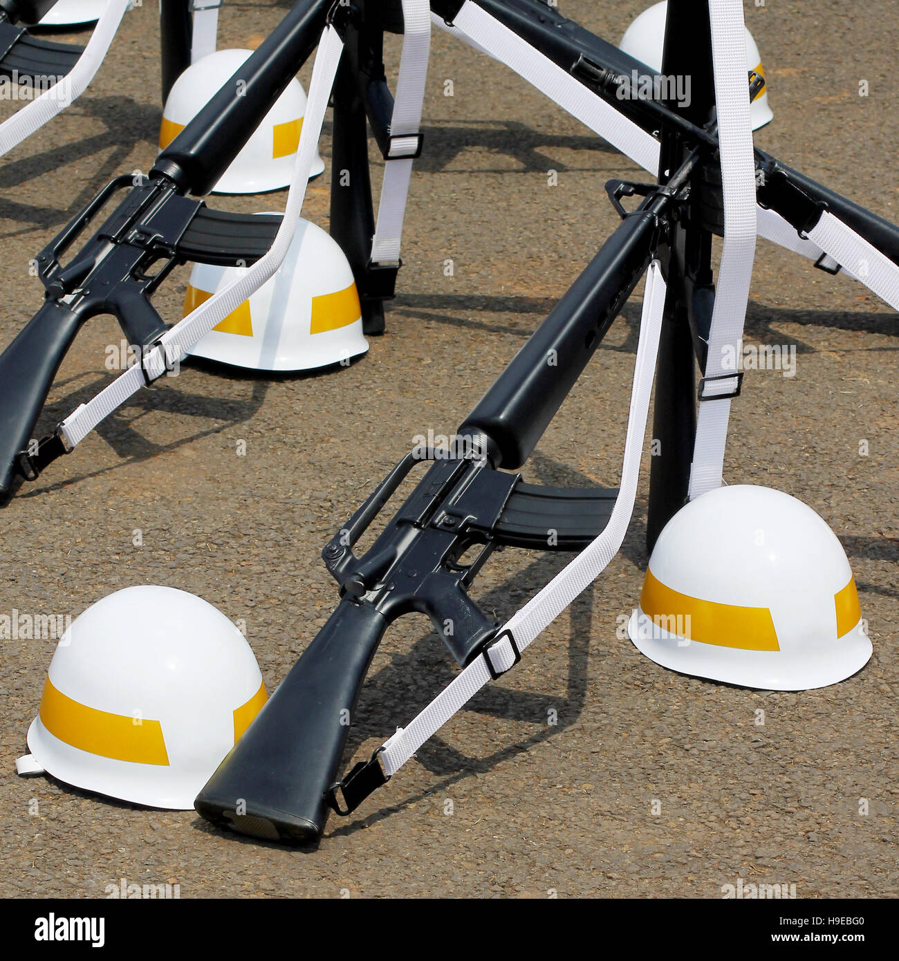 Formation de fusils d assaut et casques rayé jaune sur le sol. Banque D'Images