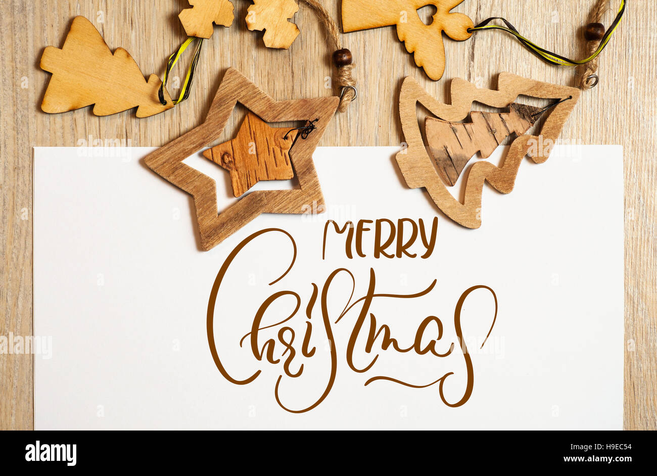 Les jouets en bois sur fond blanc avec texte Joyeux Noël. Lettrage calligraphie Banque D'Images