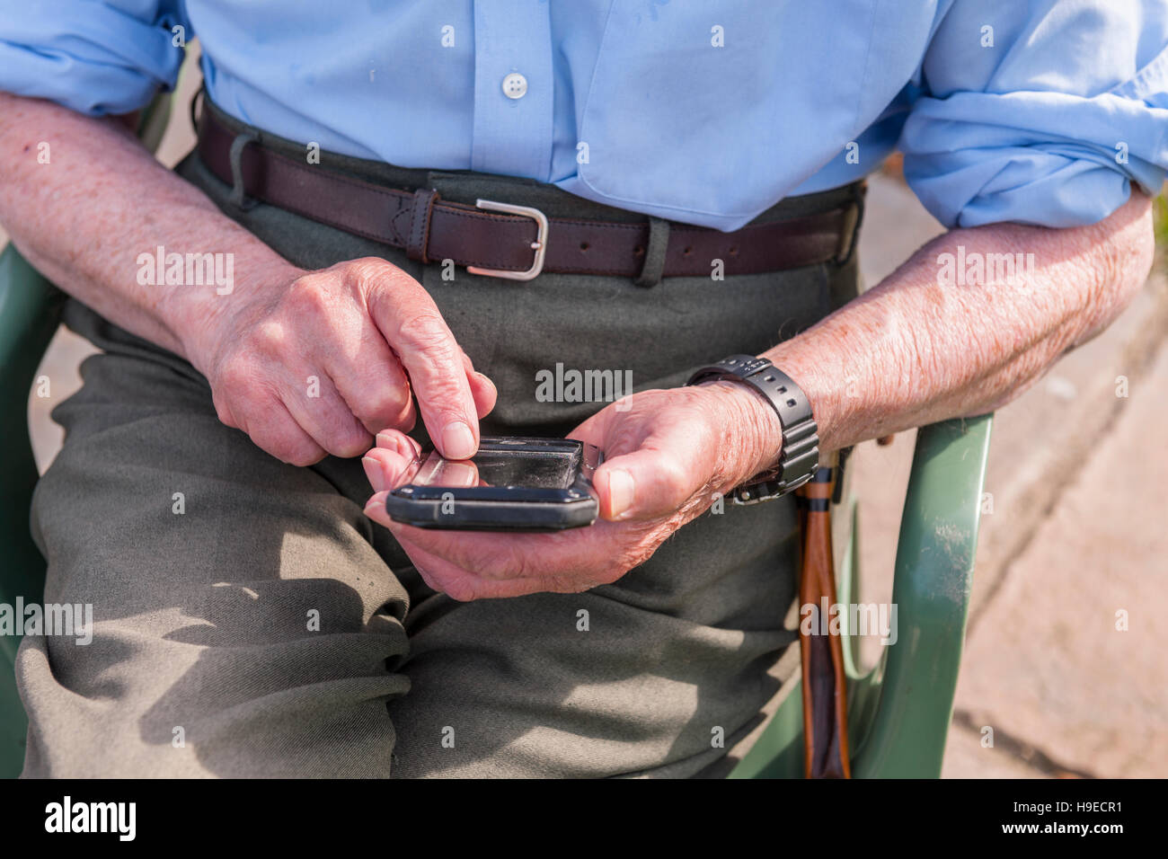 Un homme dans son 80's en utilisant un téléphone intelligent au Royaume-Uni Banque D'Images