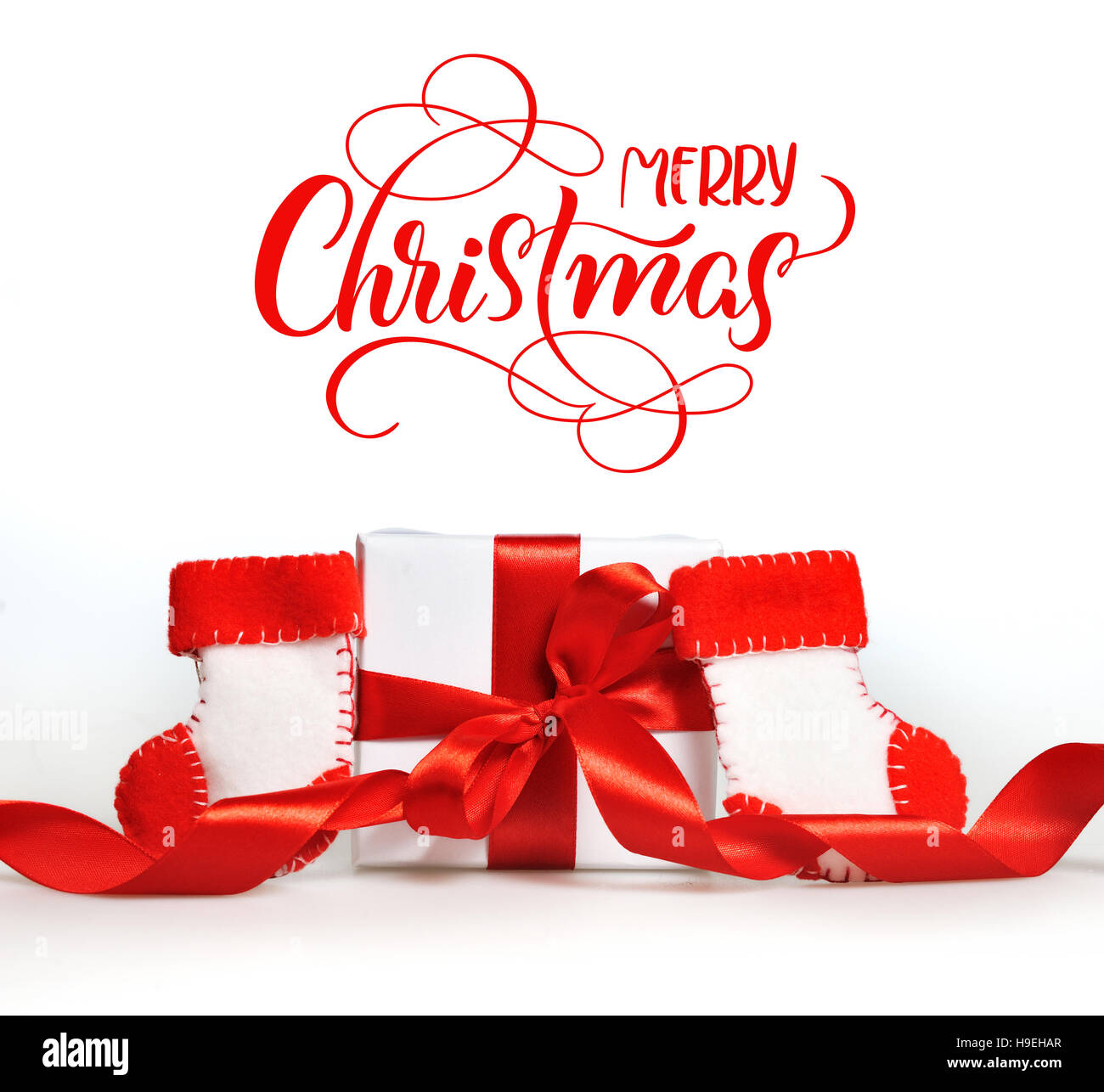 Beau cadeau boîtes avec rubans rouges branche de l'arbre et le texte Joyeux Noël. Lettrage calligraphie Banque D'Images