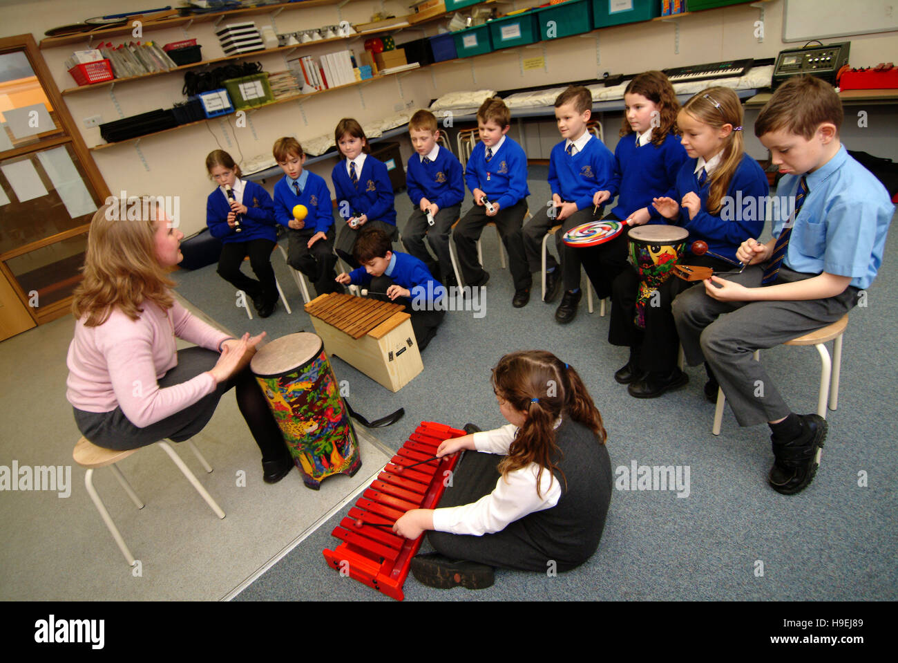 Les élèves dans le règlement uniformes bleus à Bluecoat C de l'école primaire E-Wooton-Under,EDGE,UK,dans une classe et dans une leçon de musique Banque D'Images