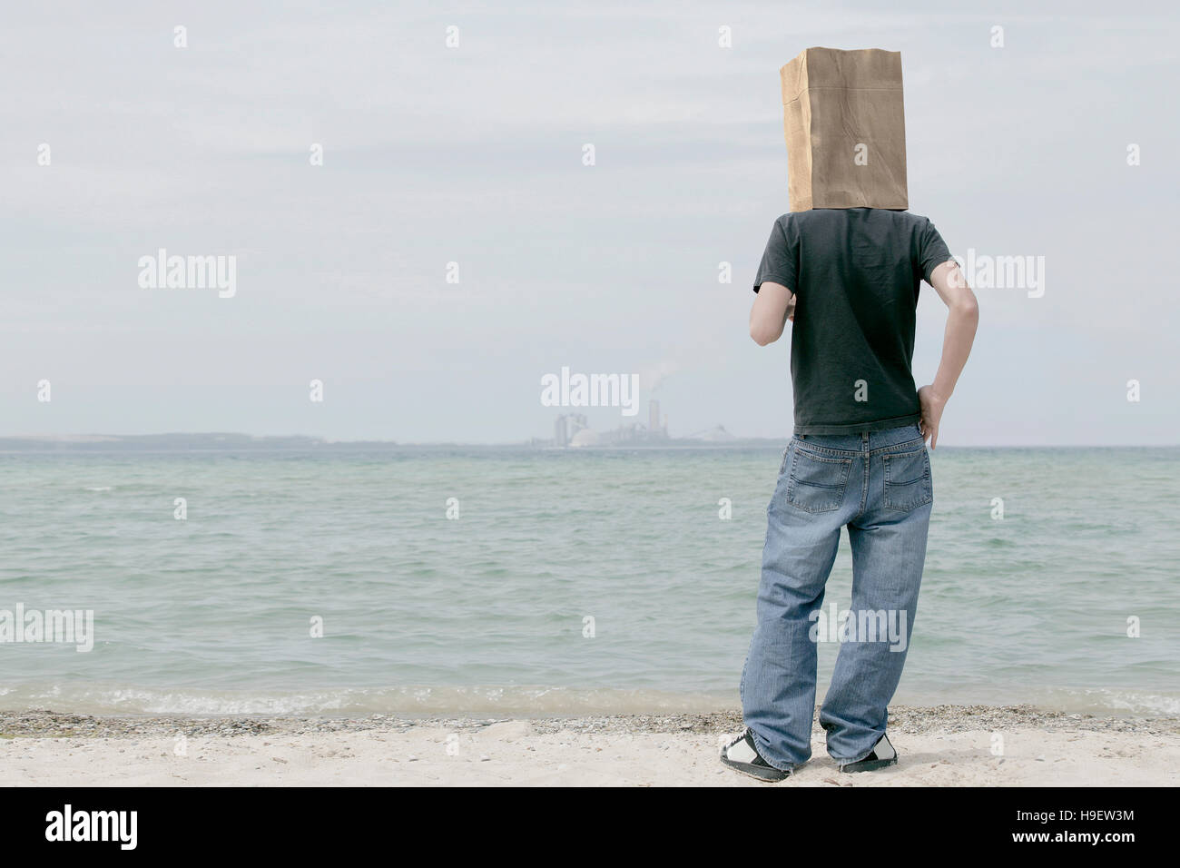 Homme portant un sac de papier sur la tête en regardant l'horizon lointain Banque D'Images