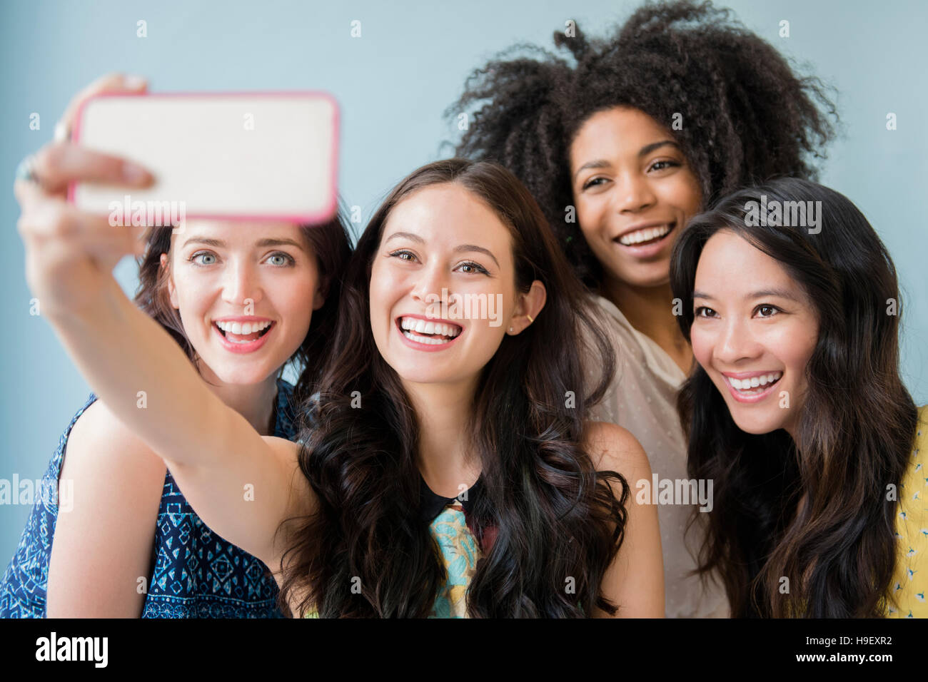 Smiling women posing for selfies téléphone cellulaire Banque D'Images