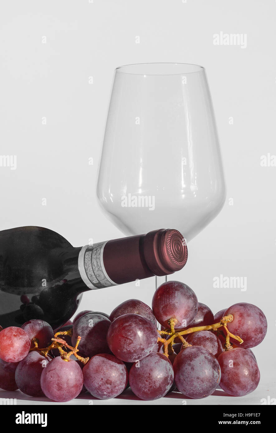 Un verre, une bouteille de vin et un peu de raisin Banque D'Images