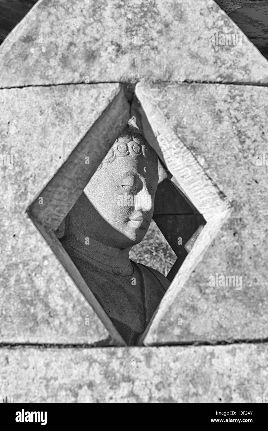 Statue de Bouddha en pierre sculptée à l'intérieur petit stupa. Photographie noir et blanc Banque D'Images