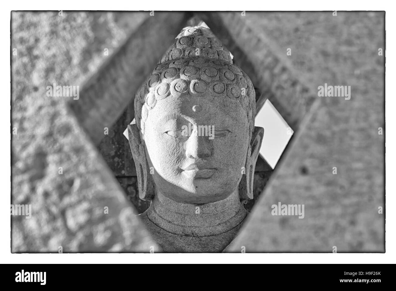 Statue de Bouddha en pierre sculptée à l'intérieur petit stupa. Photographie en noir et blanc avec une frontière vintage Banque D'Images