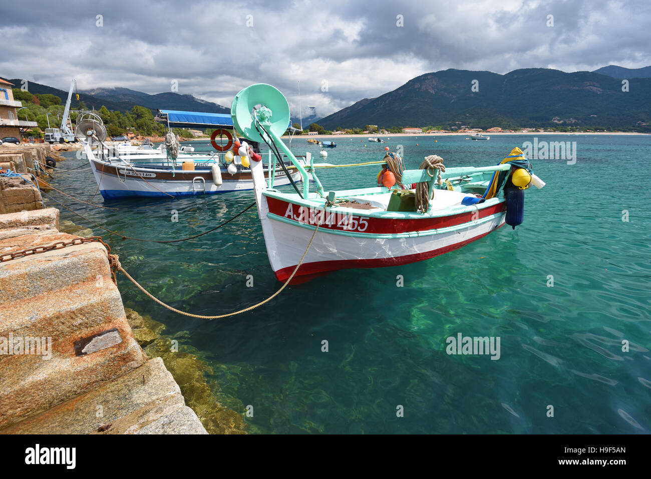 Petits bateaux de pêche près de la jetée en pierre Banque D'Images