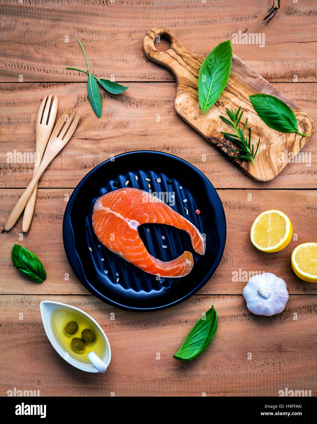 Filet de saumon cru dans la plaque noire avec des ingrédients l'huile d'olive Banque D'Images