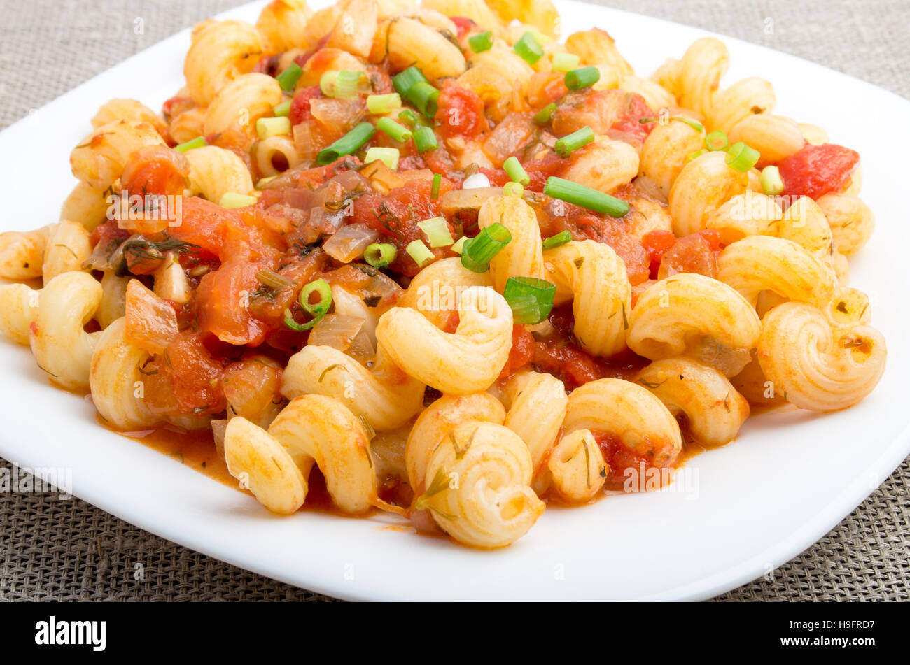 Close-Up view sur cavatappi pâtes avec une sauce à l'étuvée de légumes et les poireaux sur fond textile Banque D'Images