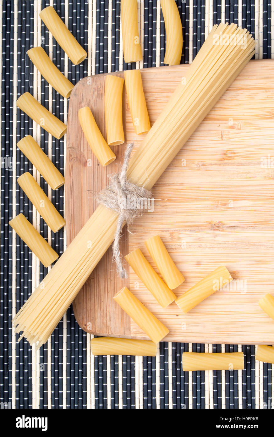 Arrière-plan de l'alimentation libre avec des spaghettis et des pâtes sur la table et le socle en bois sur un fond rayé Banque D'Images