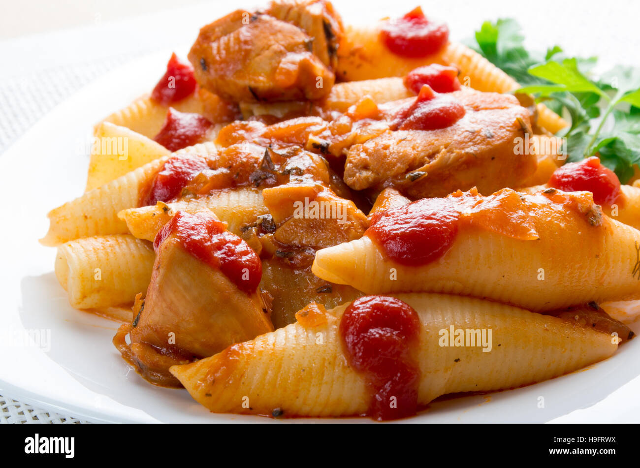 Partie du fragment de la viande de dinde et pâtes conchiglioni libre avec du ketchup et de la sauce aux légumes Banque D'Images