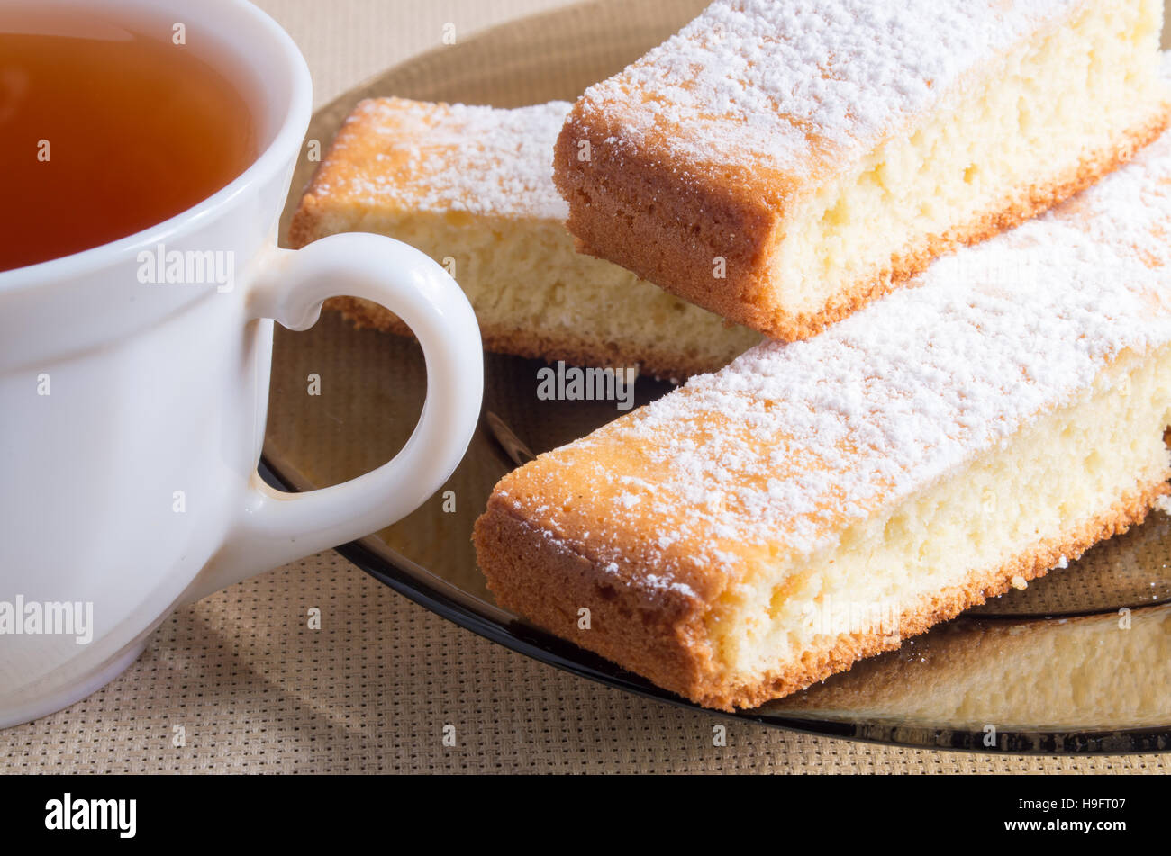 Tasse de thé noir blanc et une assiette de biscuits frais pour le petit déjeuner Banque D'Images