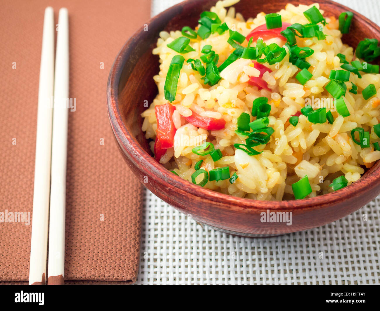 Bol en bois de riz cuit avec des légumes à la matrice de close-up avec une faible profondeur de foyer Banque D'Images