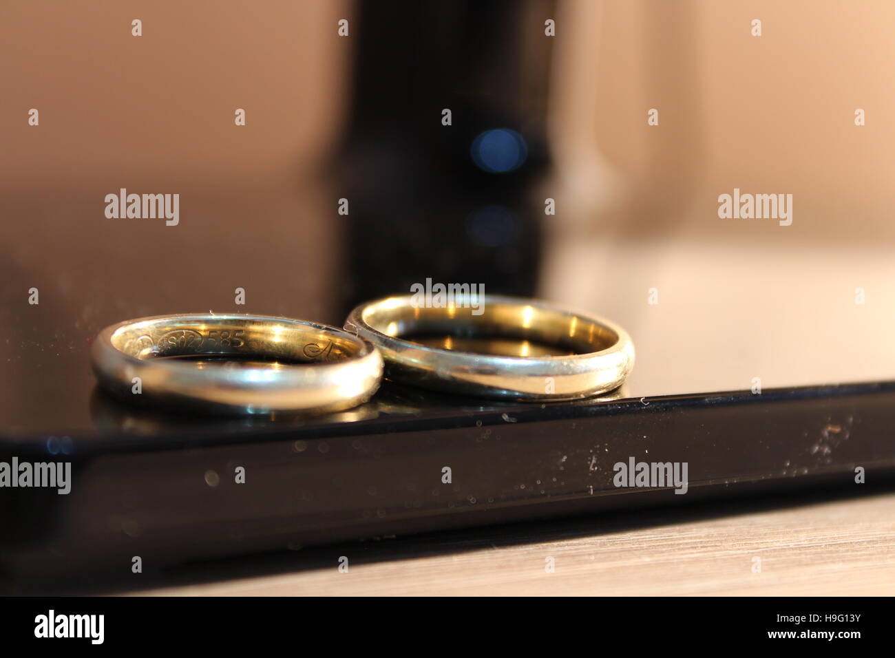 Anneaux d'or de mariage ensemble côte à côte sur un tableau noir Banque D'Images