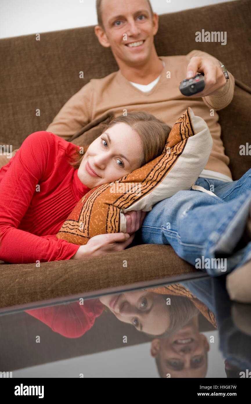 Couple de regarder la télévision sur un canapé Banque D'Images