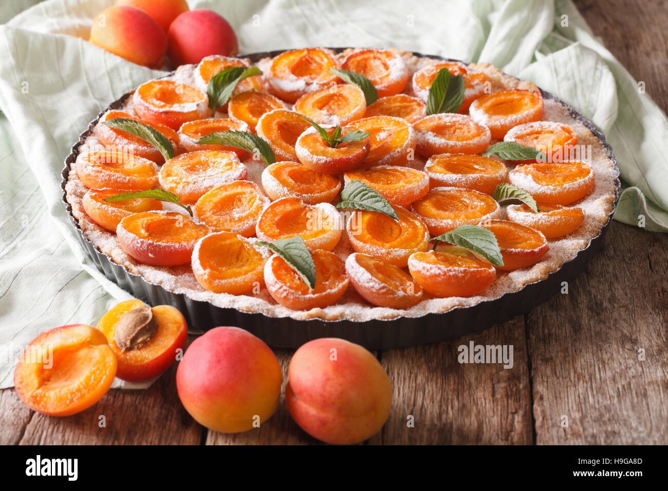 Tarte aux abricots à la menthe fraîche close up dans le plat de cuisson sur la table horizontale. Banque D'Images