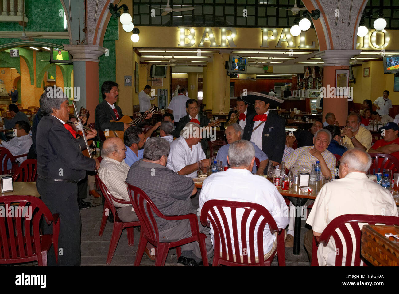 Mariachis mexicains une sérénade table des hommes âgés dans un restaurant sur la place principale de la ville de Veracruz, Mexique Banque D'Images