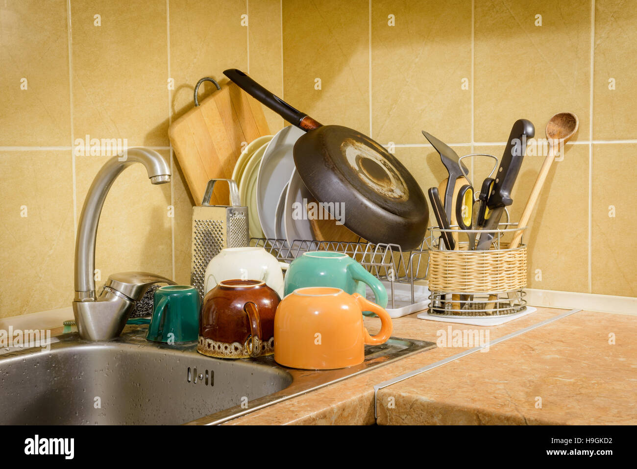 Plats, tasses, verres, assiettes, fourchettes, couteaux et cuillères sont le séchage près de l'évier, après qu'ils ont été lavés dans la cuisine Banque D'Images