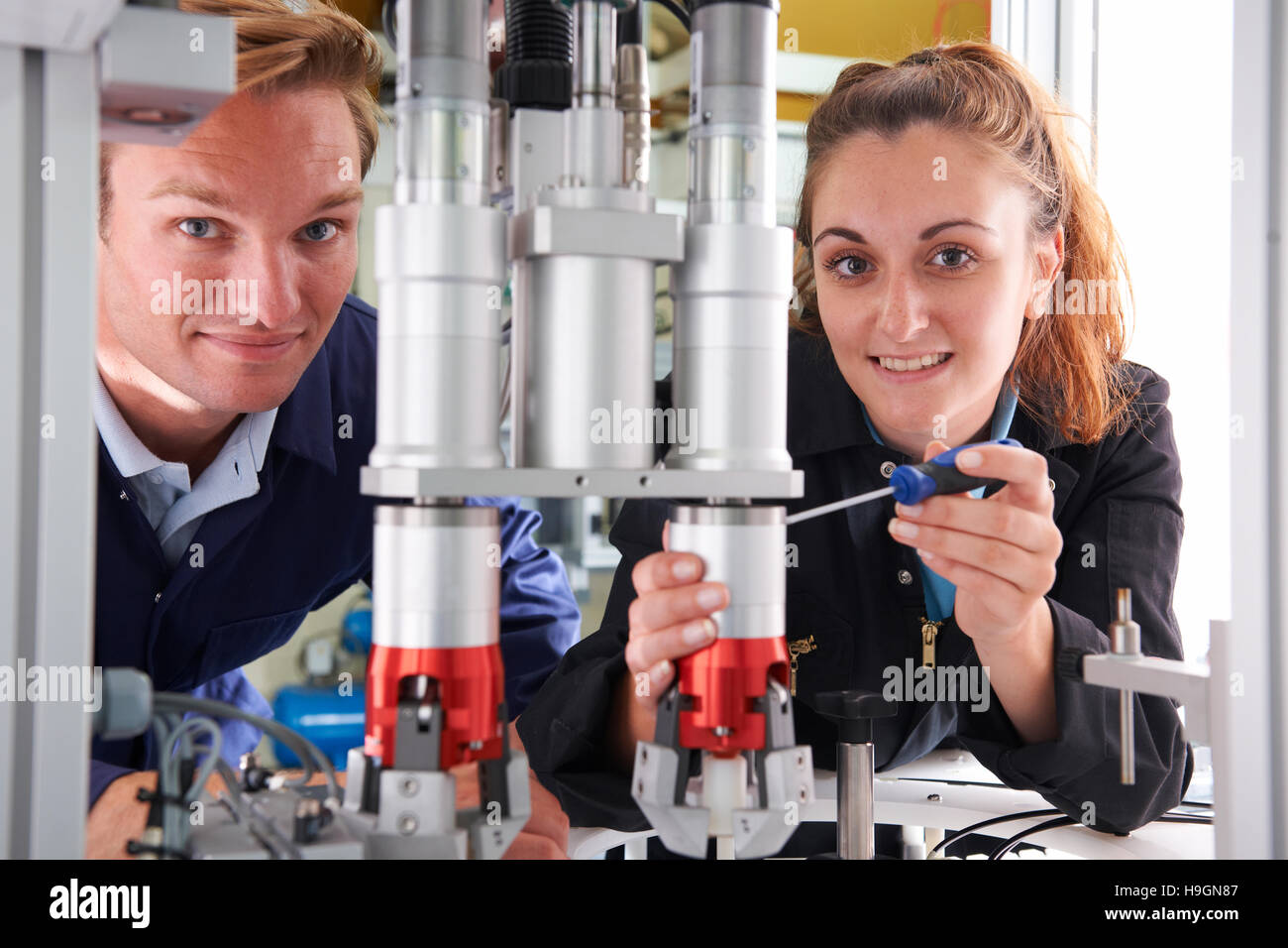 Apprenti ingénieur et de travailler sur la machine en usine Banque D'Images